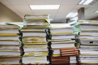 stack of books on table by Wesley Tingey courtesy of Unsplash.